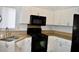 Bright kitchen features white cabinets, granite countertops, and black appliances at 1830 N Buffalo Dr # 1010, Las Vegas, NV 89128