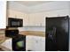 Close up of the kitchen featuring white cabinets and black appliances at 1830 N Buffalo Dr # 1010, Las Vegas, NV 89128