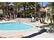 Community pool with lounge chairs and tables for residents to enjoy on a sunny day at 1830 N Buffalo Dr # 1010, Las Vegas, NV 89128