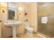 Well-lit bathroom featuring a pedestal sink, modern toilet, and a glass-enclosed shower at 2000 Fashion Show Dr # 5022, Las Vegas, NV 89109