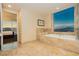 Luxurious bathroom with a soaking tub, marble tile, and city views from the window at 2000 Fashion Show Dr # 5022, Las Vegas, NV 89109