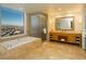 Elegant bathroom featuring a soaking tub, glass shower, and vanity with city views at 2000 Fashion Show Dr # 5022, Las Vegas, NV 89109