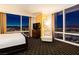 Bedroom with a king bed, chair, floor-to-ceiling windows with a city view at night, and a dresser with a TV at 2000 Fashion Show Dr # 5022, Las Vegas, NV 89109