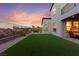 Expansive backyard boasts a pristine artificial lawn, elegant patio furniture, and exterior lighting at 2004 Peaceful Mesa Ct, Henderson, NV 89052