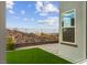 Serene backyard featuring a well-kept synthetic lawn, tasteful stone pavers, and a privacy fence with mountain views at 2004 Peaceful Mesa Ct, Henderson, NV 89052