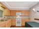 Bright kitchen with wooden cabinets, white appliances, and eat-in dining area at 2132 Chertsey Dr # B, Las Vegas, NV 89108