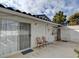 View of the outdoor patio area with sliding glass door, outdoor lights and two chairs at 2132 Chertsey Dr # B, Las Vegas, NV 89108