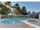 A community pool and spa are surrounded by a fence, trees, and a covered patio at 2132 Chertsey Dr # B, Las Vegas, NV 89108