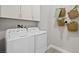 Functional laundry room with a side-by-side washer and dryer and decorative wall baskets at 214 Piazzetta Pl, Henderson, NV 89011