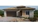 Charming single-story home showcasing a tile roof, stone accents, desert landscaping, and a two-car garage at 218 Piazzetta Pl, Henderson, NV 89011