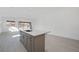 Modern kitchen island with sink and cabinets overlooks a bright living area with tile floors at 218 Piazzetta Pl, Henderson, NV 89011