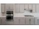 Modern kitchen showcasing stainless steel appliances, gray cabinets, and subway tile backsplash at 218 Piazzetta Pl, Henderson, NV 89011