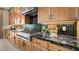 Gourmet kitchen showcasing stainless steel appliances, custom cabinets, and black marble countertops at 227 Paraggi Bay Dr, Henderson, NV 89011