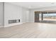Spacious living room area with modern fireplace, sliding glass doors to the outdoor patio and sleek flooring at 241 Paraggi Bay Dr, Henderson, NV 89011