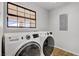Bright laundry room featuring modern washer and dryer, tile flooring, and a window for natural light at 2935 Hardin Dr, Henderson, NV 89074