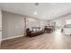 Open living room area with wood-look tile flooring, dining set, and access to the backyard at 3323 Bay Horse Ct, North Las Vegas, NV 89032