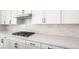 Close-up of kitchen featuring white cabinets, quartz countertops, subway tile, and stainless steel appliances at 346 Tigullio Ave, Henderson, NV 89011