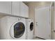 Efficient laundry room features modern washer and dryer with storage cabinets above at 3544 Tack St, Las Vegas, NV 89122