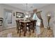 Dining room with a wooden table set, stylish lighting, and tile flooring adjacent to the living area at 3752 Calle De Rio Ave, Las Vegas, NV 89115
