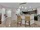 Kitchen with an open bar area, featuring pendant lighting, dark cabinets, and tile floors leading to the hallway at 3752 Calle De Rio Ave, Las Vegas, NV 89115