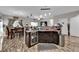 Functional kitchen with dark wood cabinets, tile backsplash, a breakfast bar, and an open view of the dining area at 3752 Calle De Rio Ave, Las Vegas, NV 89115