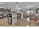 Open-concept kitchen featuring dark cabinetry, stainless steel appliances, a breakfast bar, and tile floors at 3752 Calle De Rio Ave, Las Vegas, NV 89115