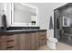 Modern bathroom with a dark wood vanity, large mirror, and walk-in shower at 42 Ravenswood Ave, Las Vegas, NV 89141