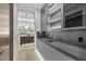 Modern butler's pantry boasts gray cabinetry, stone countertops, and sleek glass-front upper cabinets with lighting at 42 Ravenswood Ave, Las Vegas, NV 89141
