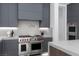 Modern kitchen with gray cabinets, stainless steel Wolf range, and contemporary design details at 42 Ravenswood Ave, Las Vegas, NV 89141