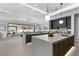 Open kitchen with an island, gray cabinets, modern lighting, and seamless access to the living space at 42 Ravenswood Ave, Las Vegas, NV 89141