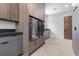 Modern laundry area features gray cabinets, stone counters, and stacked washer/dryer units for efficient space-saving design at 42 Ravenswood Ave, Las Vegas, NV 89141
