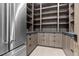Spacious walk-in pantry features ample wood shelving, drawers, and stone countertop adjacent to a stainless steel refrigerator at 42 Ravenswood Ave, Las Vegas, NV 89141
