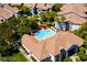 Aerial shot of a community pool with red umbrellas, surrounded by lush landscaping and multiple buildings at 45 Maleena Mesa St # 223, Henderson, NV 89074