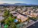 Aerial view of a landscaped neighborhood highlighting pools, tennis courts, and residences with scenic mountain views at 4737 Barcelona Ridge Ct, Las Vegas, NV 89129