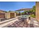 Backyard with a storage shed, tennis/pickleball court, and patio dining set under an umbrella at 4737 Barcelona Ridge Ct, Las Vegas, NV 89129