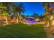 Inviting backyard with a pool, slide, lounge chairs, palm trees and manicured landscaping at 4737 Barcelona Ridge Ct, Las Vegas, NV 89129