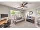 Bedroom featuring a ceiling fan, grey couch, and natural light from the window at 4737 Barcelona Ridge Ct, Las Vegas, NV 89129
