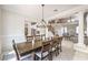 Elegant dining room with wood table, modern chandelier, and view of the staircase and living area at 4737 Barcelona Ridge Ct, Las Vegas, NV 89129