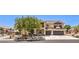 Charming two-story home with a stucco facade, a two-car garage, manicured landscaping, and a mature shade tree at 4737 Barcelona Ridge Ct, Las Vegas, NV 89129