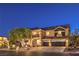 Exterior of a two-story house at dusk featuring a three-car garage and manicured landscaping at 4737 Barcelona Ridge Ct, Las Vegas, NV 89129