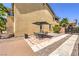Home's side exterior featuring a patio dining set and a paved driveway with decorative gravel at 4737 Barcelona Ridge Ct, Las Vegas, NV 89129