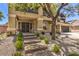 Inviting front entry featuring a lush tree, stone pathway and an elegant covered porch at 4737 Barcelona Ridge Ct, Las Vegas, NV 89129