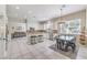 Bright kitchen featuring white cabinets, an island with bar seating, stainless steel appliances, and a dining area at 4737 Barcelona Ridge Ct, Las Vegas, NV 89129