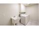 Bright laundry room with white cabinets, a utility sink, and a modern washer and dryer set at 4737 Barcelona Ridge Ct, Las Vegas, NV 89129