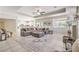 Open living space with tile flooring, a large sectional sofa, and a view into the modern kitchen at 4737 Barcelona Ridge Ct, Las Vegas, NV 89129