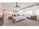Spacious primary bedroom with a ceiling fan, plenty of natural light, and comfortable seating area at 4737 Barcelona Ridge Ct, Las Vegas, NV 89129