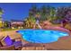 Inviting backyard pool with slide, lounge chairs, and lush landscaping for relaxation and recreation at 4737 Barcelona Ridge Ct, Las Vegas, NV 89129