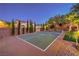 Evening shot of a backyard sport court surrounded by lush landscaping, a wonderful amenity for recreation and enjoyment at 4737 Barcelona Ridge Ct, Las Vegas, NV 89129