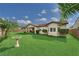 Landscaped backyard featuring lush green grass, mature trees, and a covered patio perfect for outdoor relaxation at 5170 Agio Ave, Pahrump, NV 89061