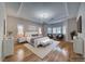 Serene main bedroom featuring a chandelier, tray ceiling, and hardwood floors at 5170 Agio Ave, Pahrump, NV 89061